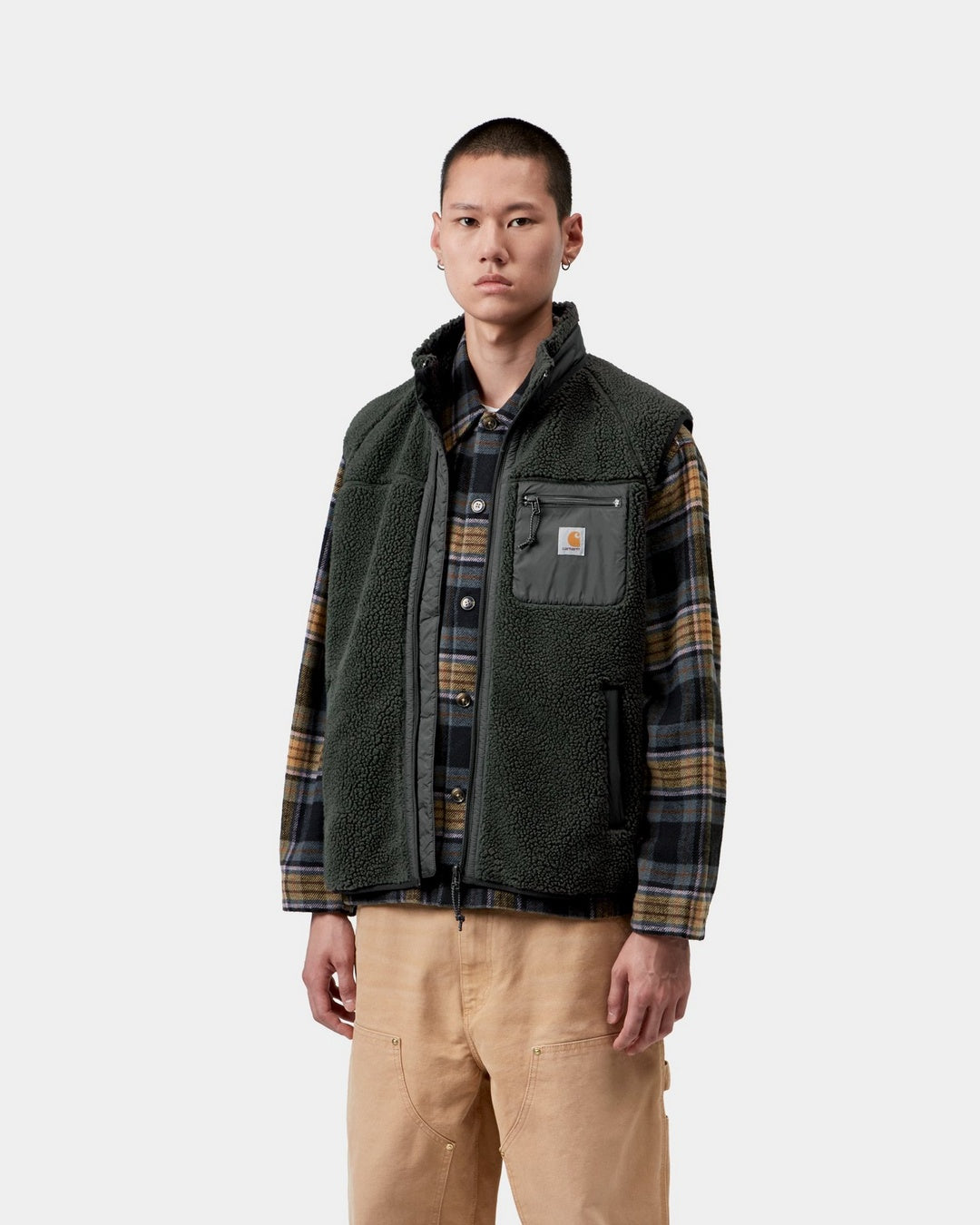 Carhartt WIP Prentis Vest Liner in Raven / Black, front view, worn over a plaid shirt, with chest pocket and Square Label visible.