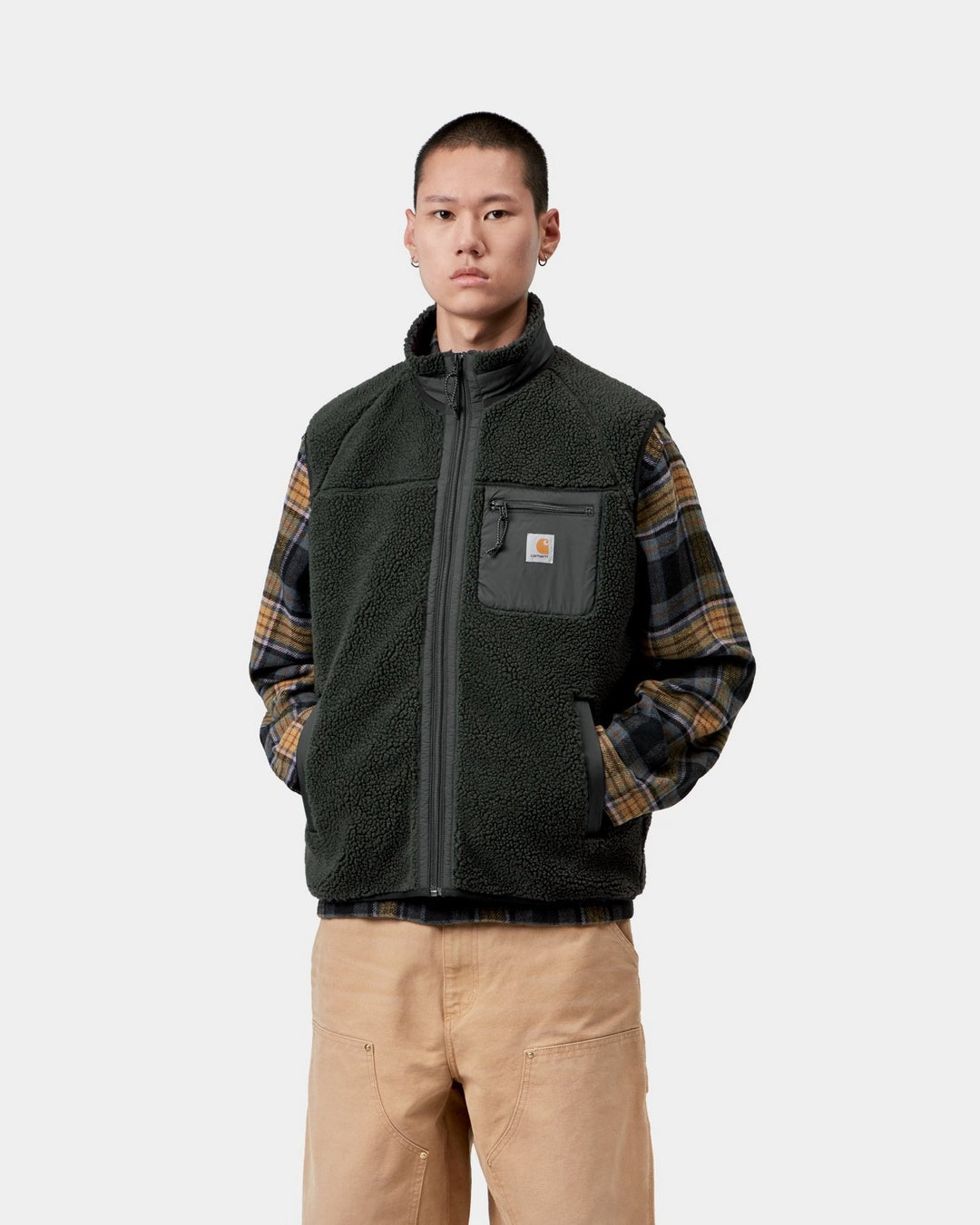 Carhartt WIP Prentis Vest Liner in Raven / Black, front view, worn over a plaid shirt with zip chest pocket and Square Label.