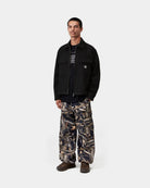 Model wearing Carhartt WIP Atoka Shirt Jac in Black, front view with two-way zip open, showing chest flap pockets and Square Label.