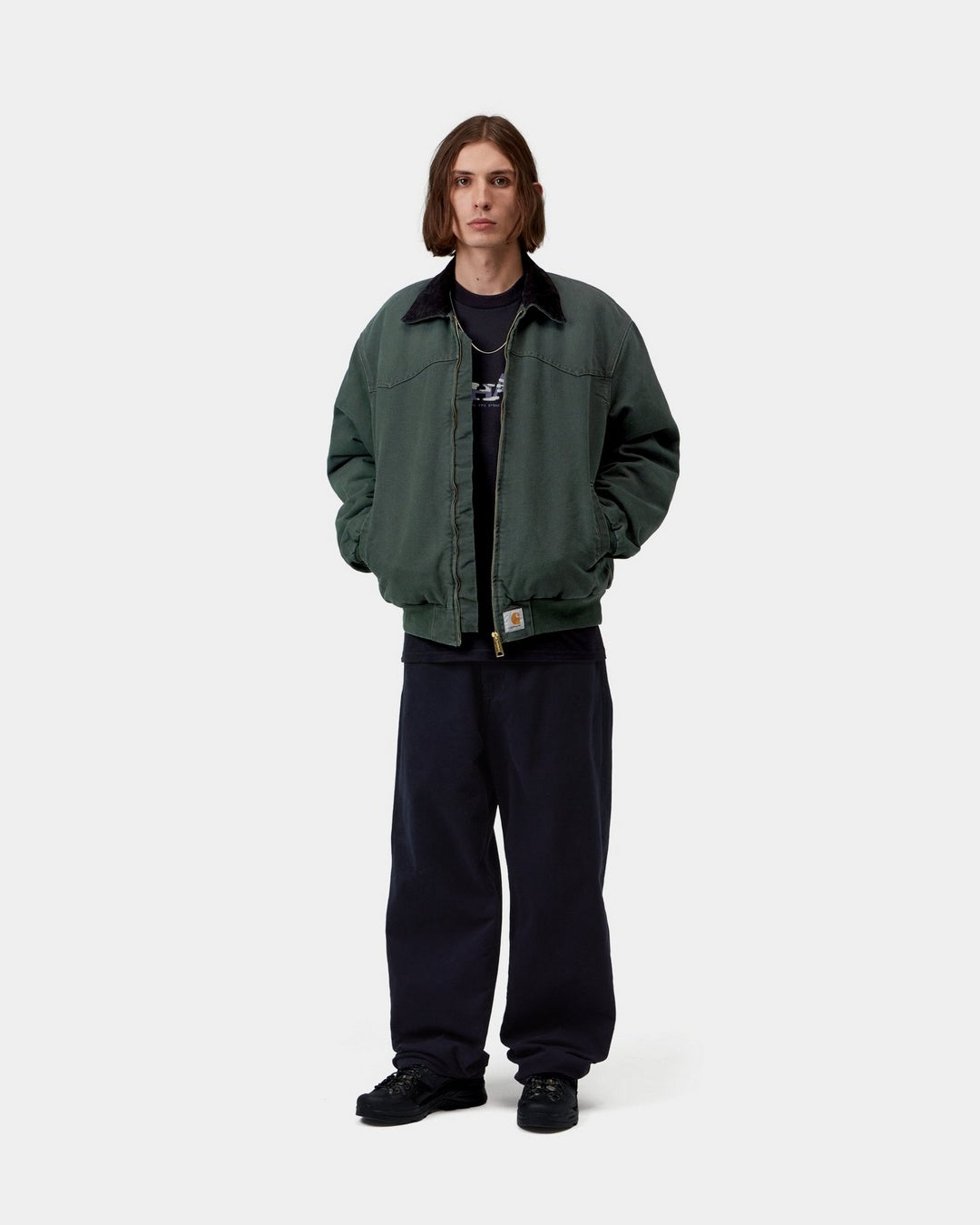 Carhartt WIP OG Santa Fe Jacket in Raven / Black, front view on model, with corduroy collar and front zip closure.