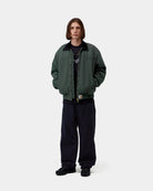 Carhartt WIP OG Santa Fe Jacket in Raven / Black, front view on model, with corduroy collar and front zip closure.