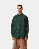 Carhartt WIP L/S OG Madison Shirt in Dark Scarab, front view, buttoned up with button-down collar and embroidered chest logo, shown on model.
