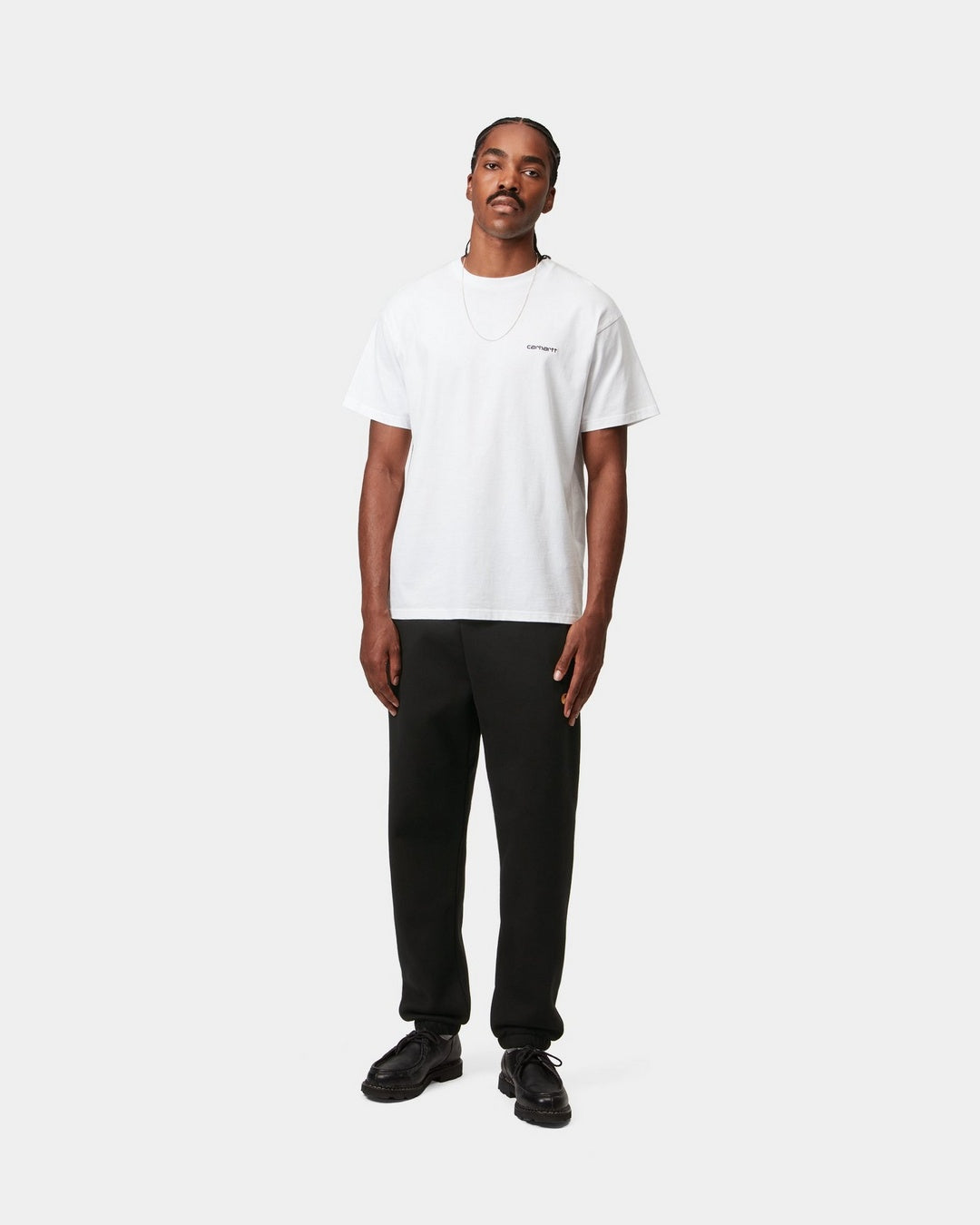Carhartt WIP Chase Sweat Pant in Black / Gold, shown on model with a straight-leg fit and elasticated cuffs.