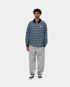 Carhartt WIP Chase Sweat Pant in Grey Heather / Gold, front view, with embroidered logo on the thigh and elasticated cuffs, shown on model.