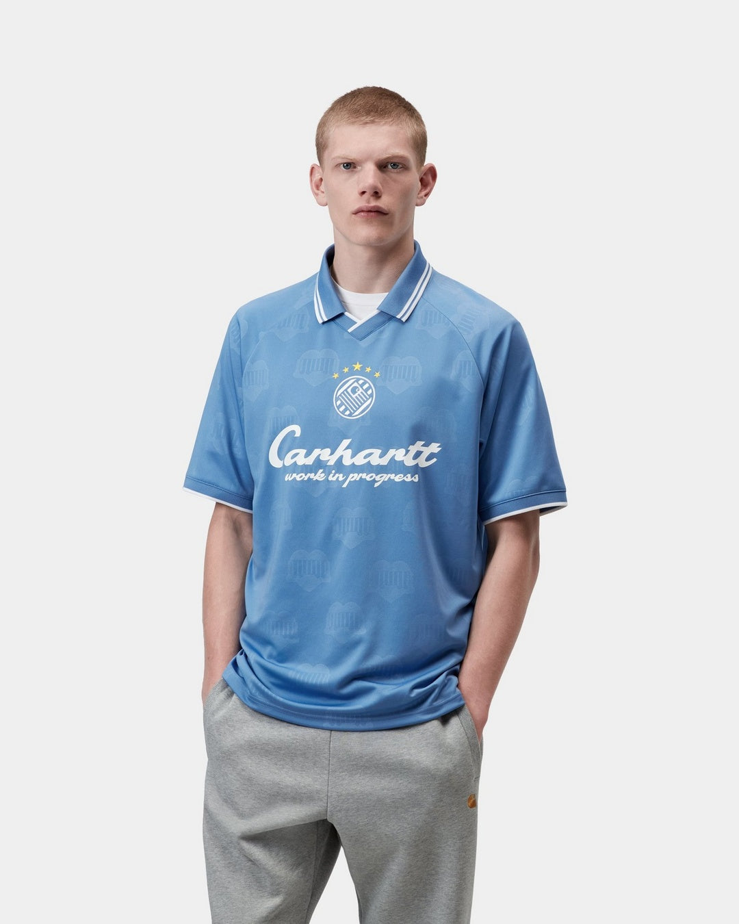 Carhartt WIP S/S Terrace Football T-Shirt in Curacao, front view with allover heart train jacquard, collar, and white graphic print on the chest.