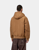 Carhartt WIP OG Active Jacket in WIP H Brown, back view, showing hooded canvas jacket with ribbed hem and cuffs, shown on model.