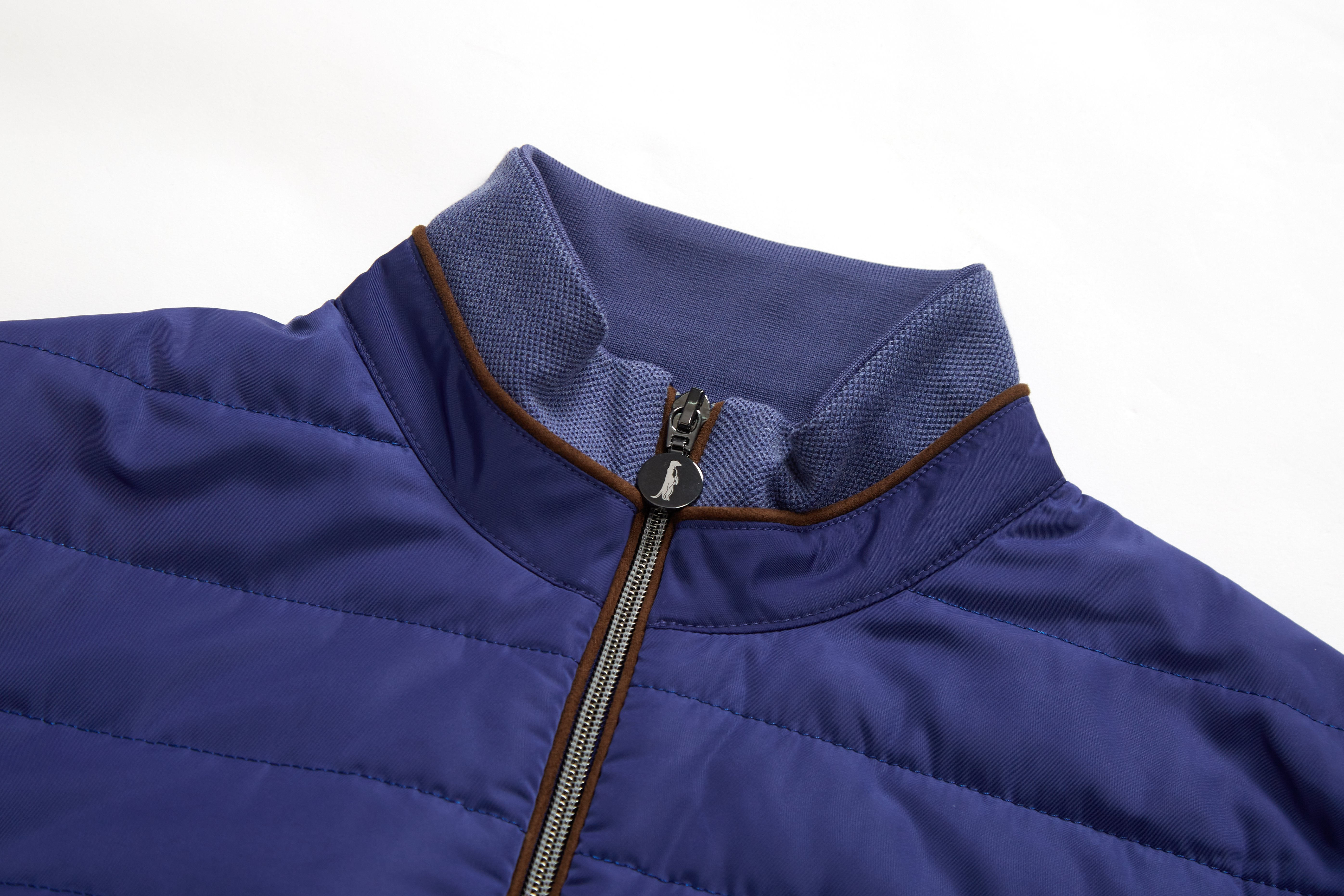 Close-up of a blue puffer jacket with a zipper on a white background