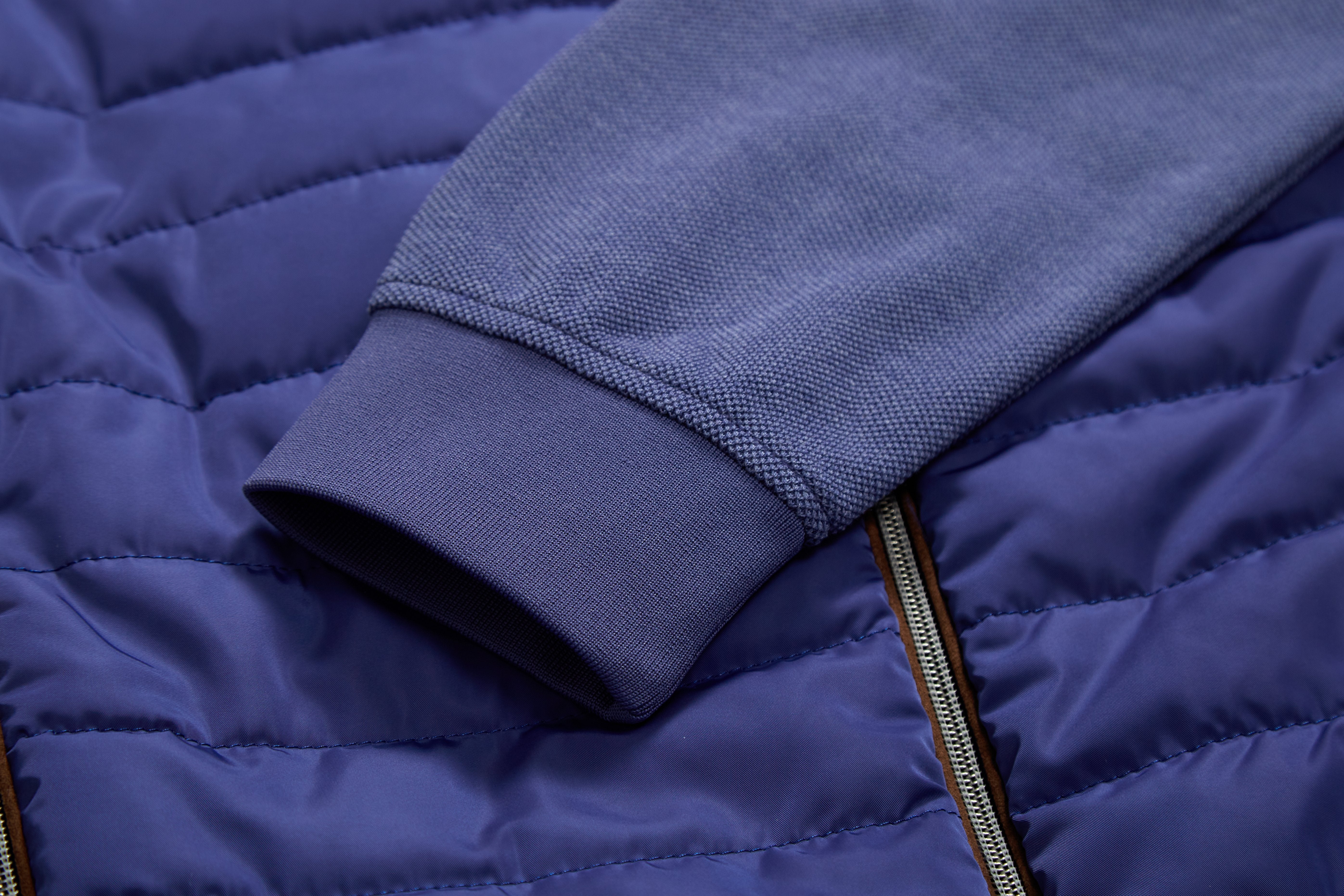 Close-up of a blue puffer jacket with a focus on the collar and fabric texture.