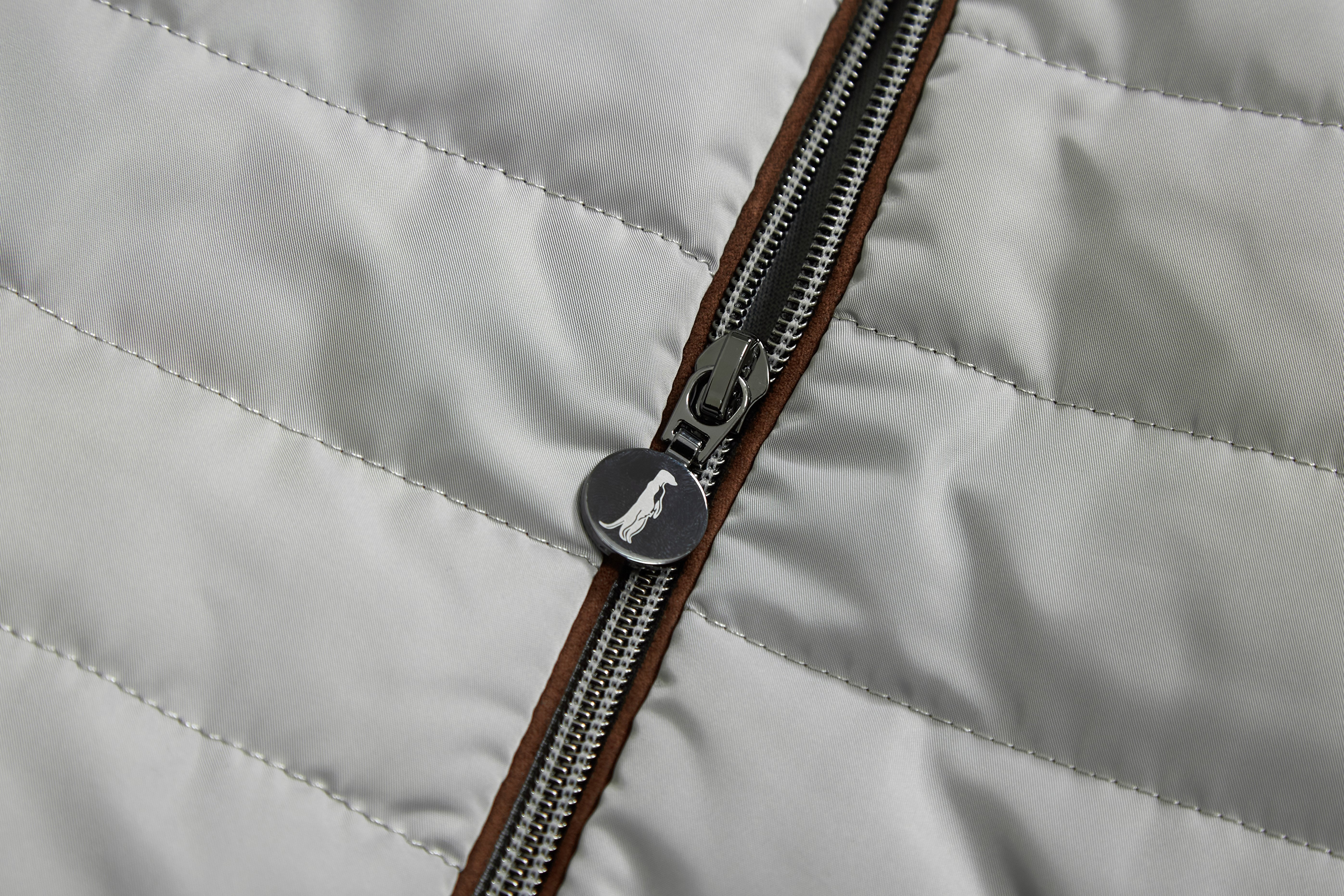 Close-up of a zipper on a quilted gray jacket