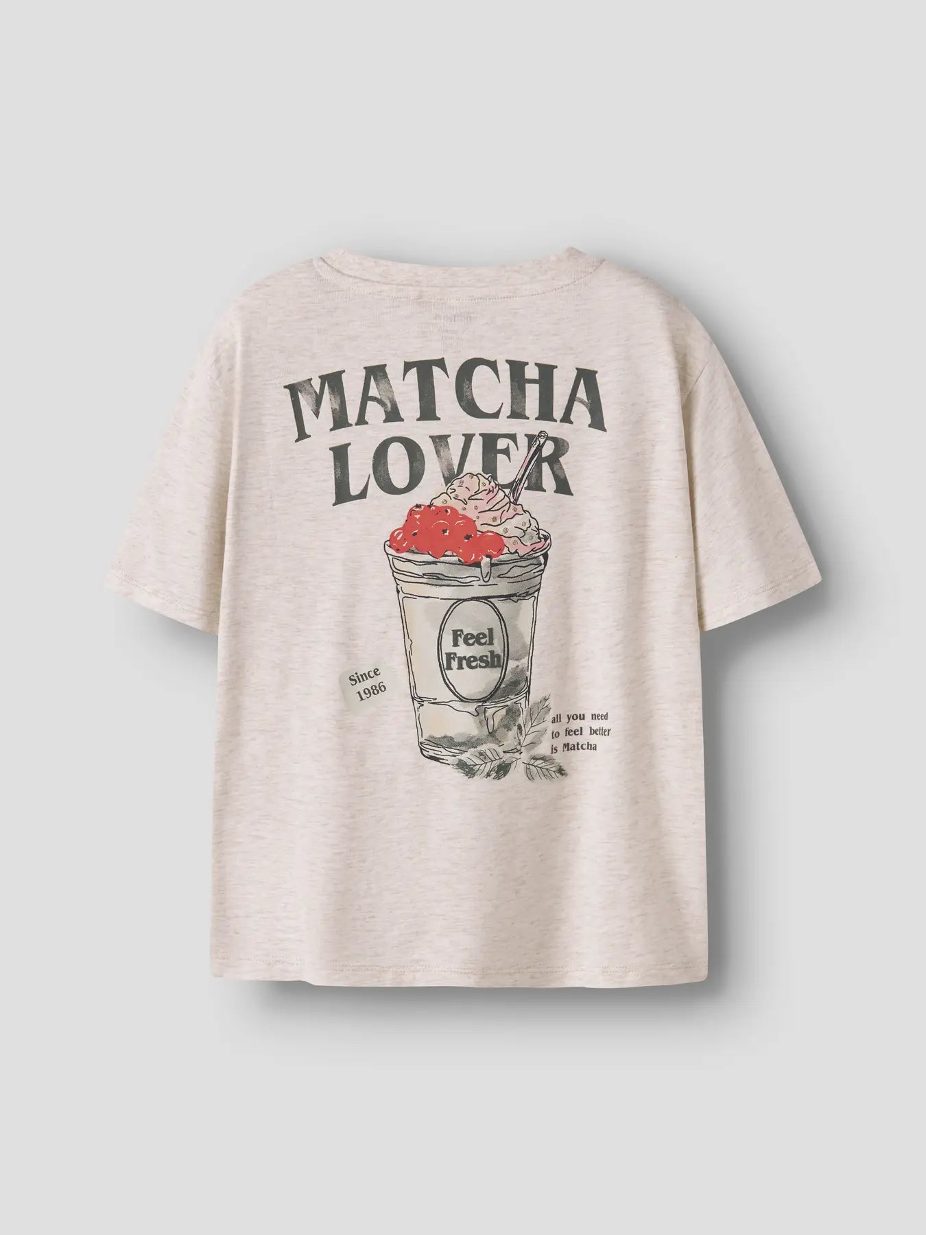 Beige t-shirt with 'Matcha Lover' graphic design on a light gray background