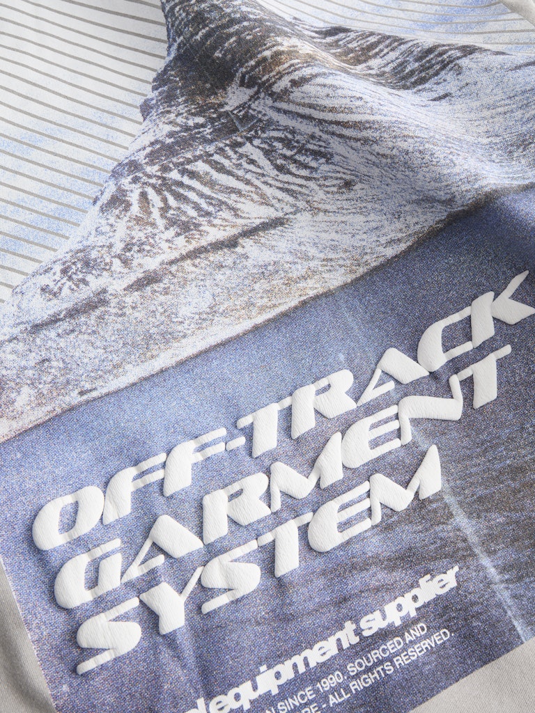 Textile with 'Off-Track Garment System' branding on a textured background