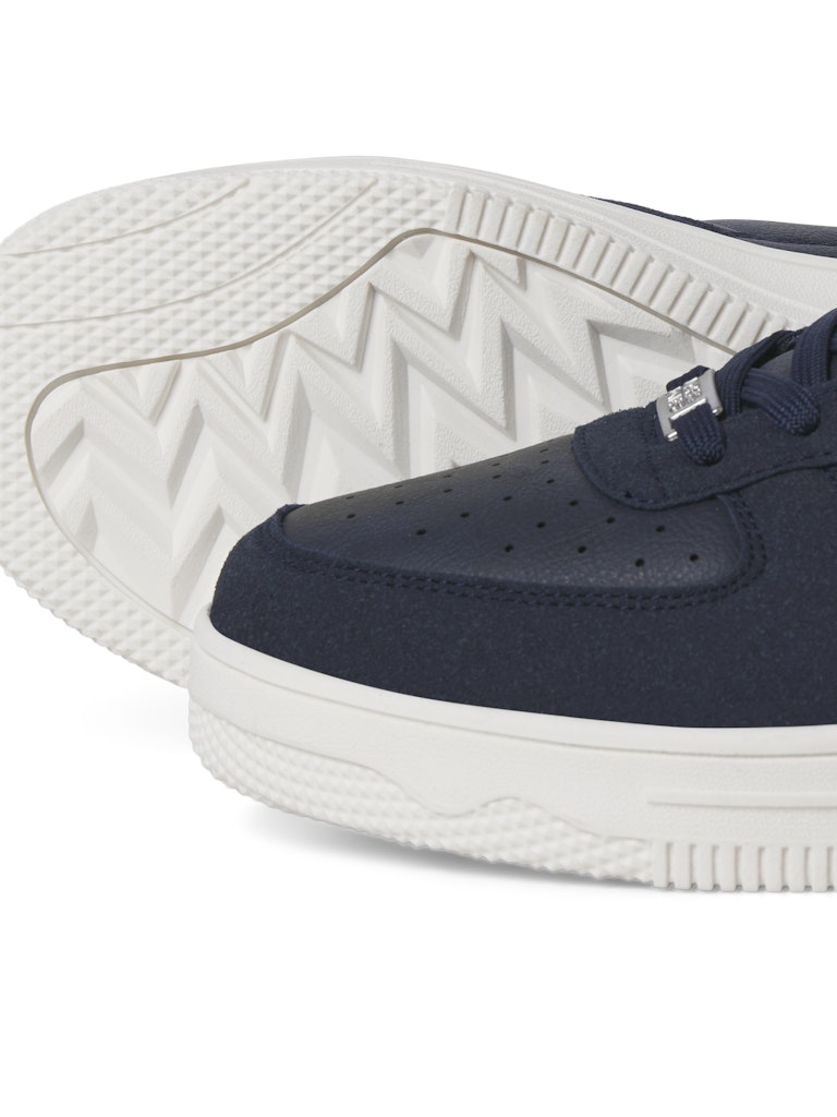 Navy sneaker with white sole on a white background