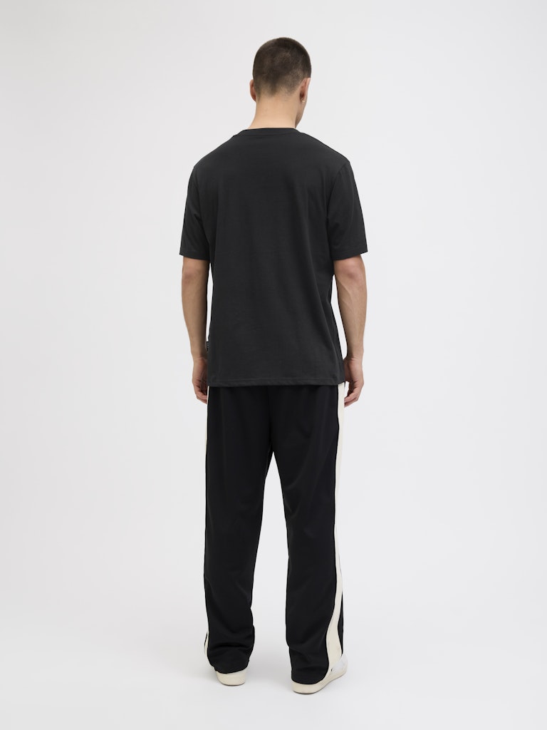 Man wearing a black t-shirt and pants on a white background