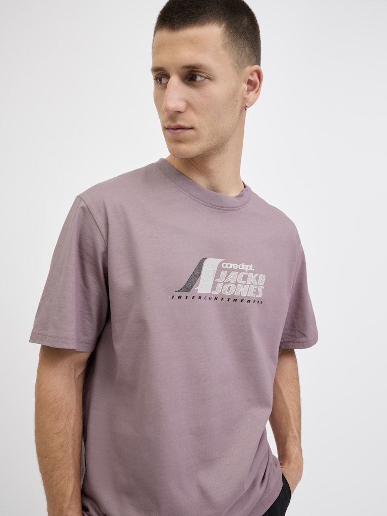 Man wearing a mauve t-shirt with a logo and text on a white background