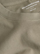 Close-up of a green t-shirt with 'Jack & Jones' branding and text on the collar.