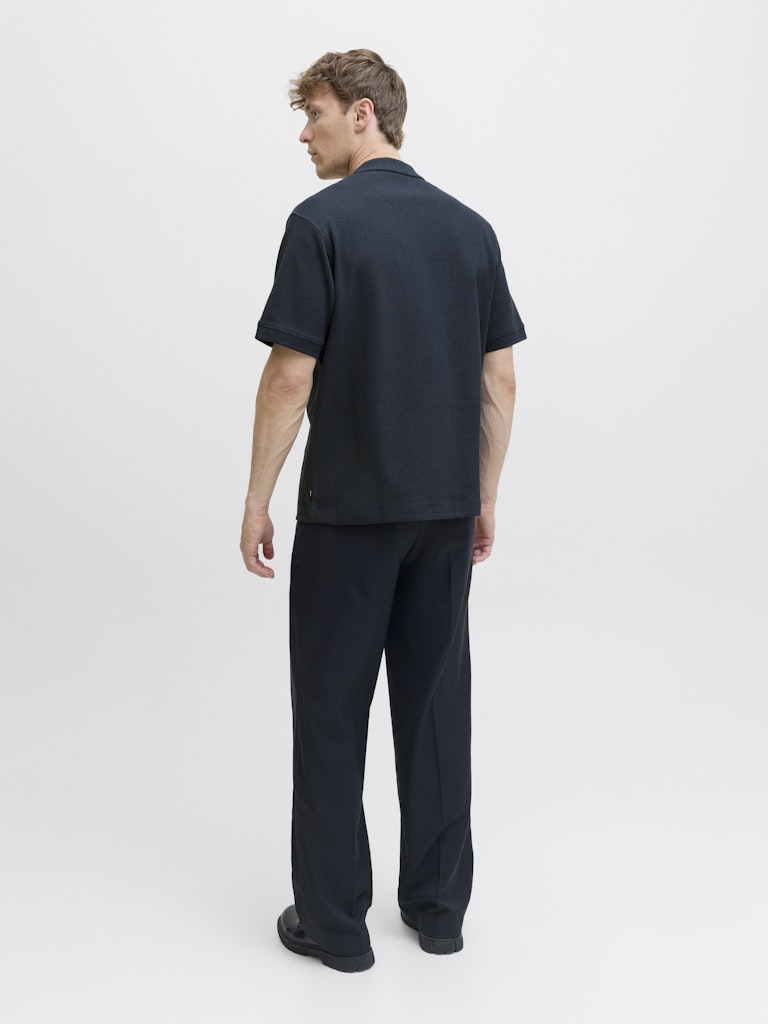 Man wearing a navy blue t-shirt and pants on a white background