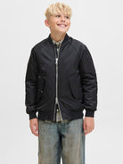 Junior boys black bomber jacket worn with casual outfit