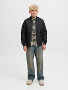 Junior boys black bomber jacket styled with checked shirt and jeans