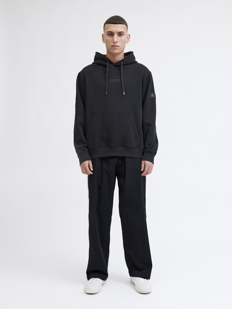 Man wearing a black hoodie and pants on a white background