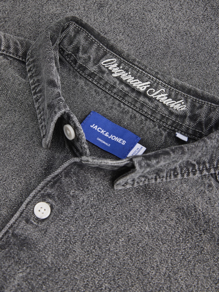 Close-up of a gray shirt with a Jack & Jones label on a dark background