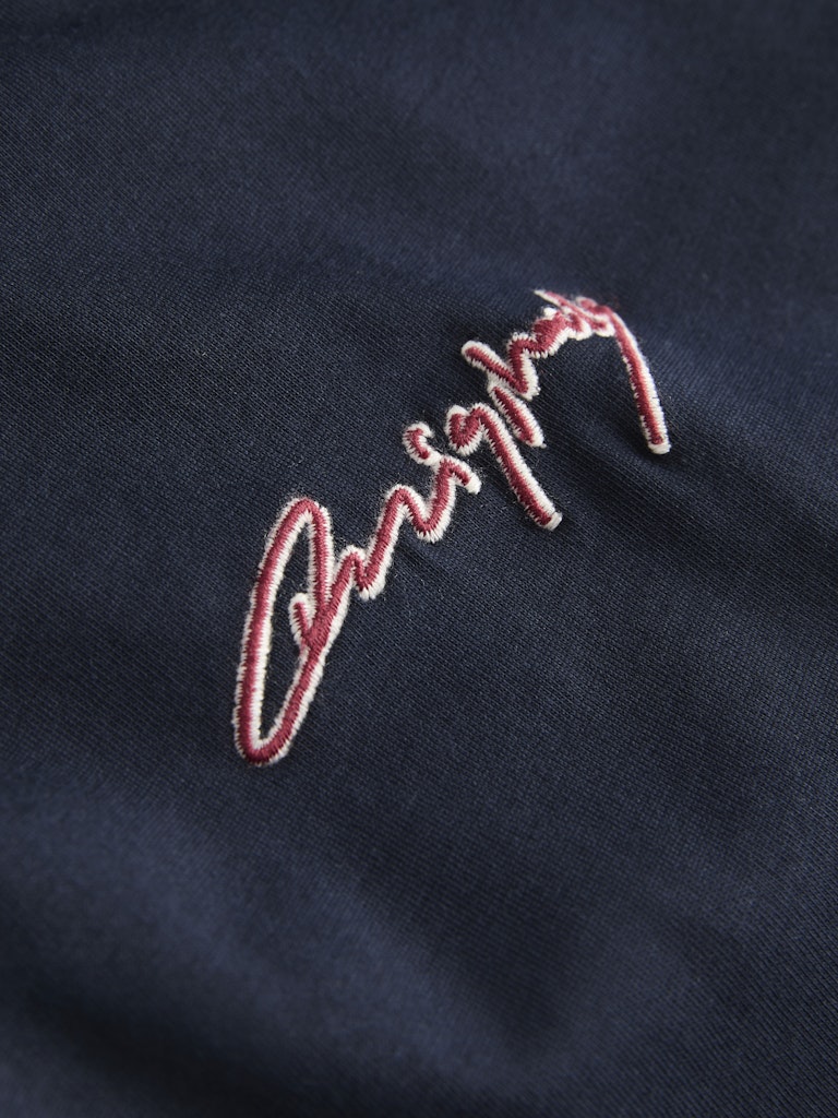 Embroidered logo on a dark fabric background