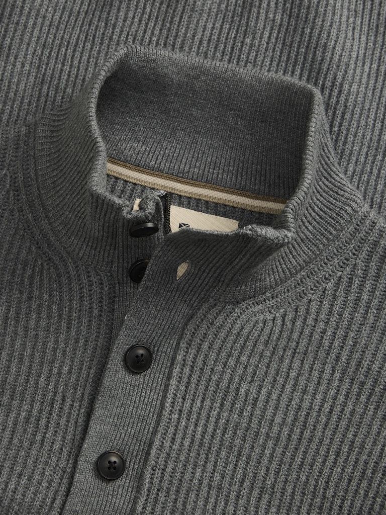 Close-up of a gray ribbed sweater with buttons and a collar.