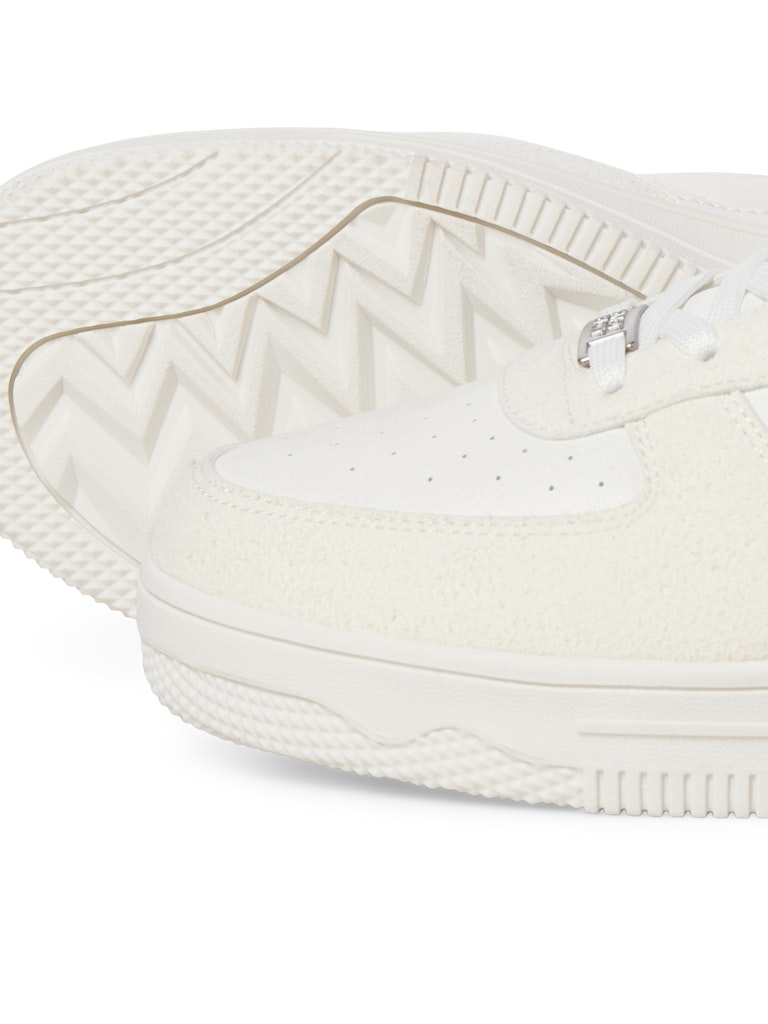 Close-up of a white sneaker with brand logo on a white background