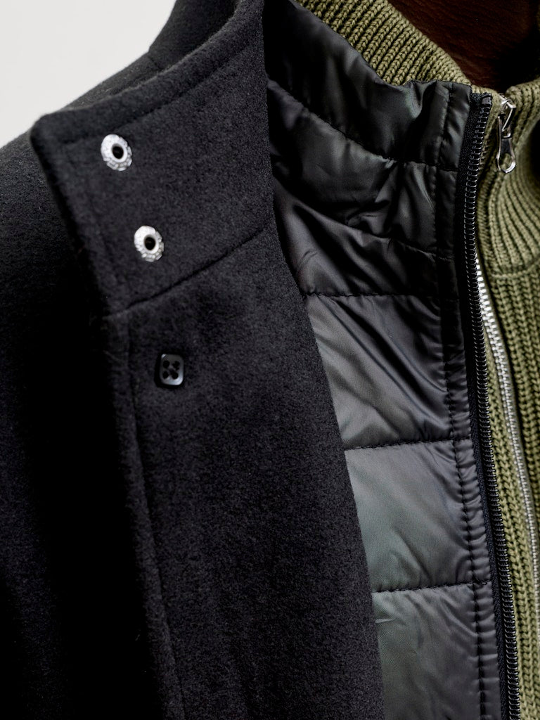 Close-up of a black jacket with a quilted green interior