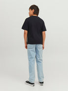 Child wearing a black t-shirt and light blue jeans on a white background