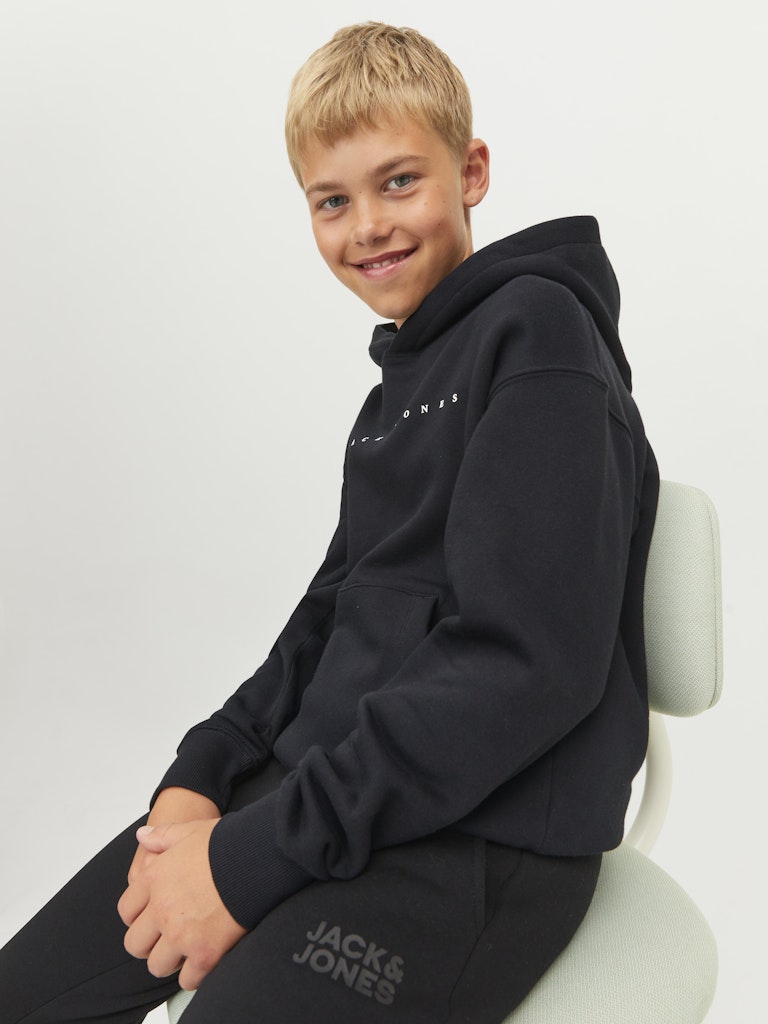 Child wearing a black hoodie with 'Jack & Jones' branding on a white background
