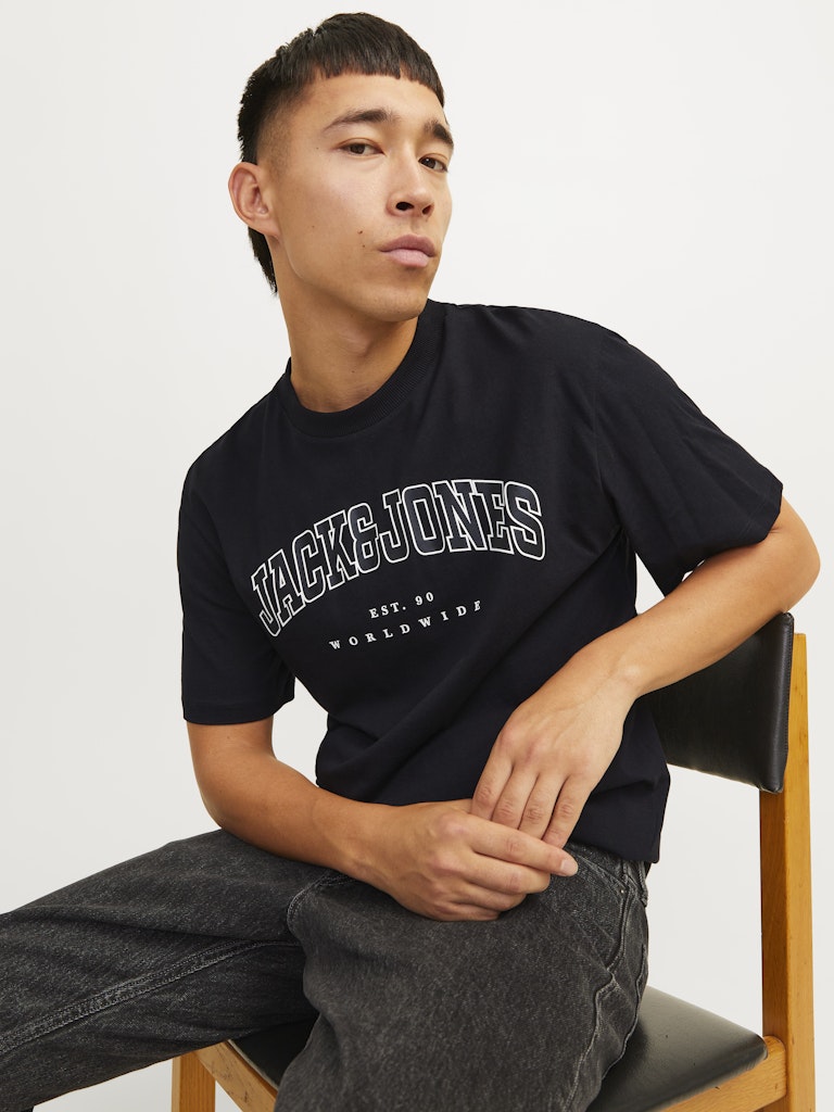 Caleb Varsity Black Tee-Model sitting