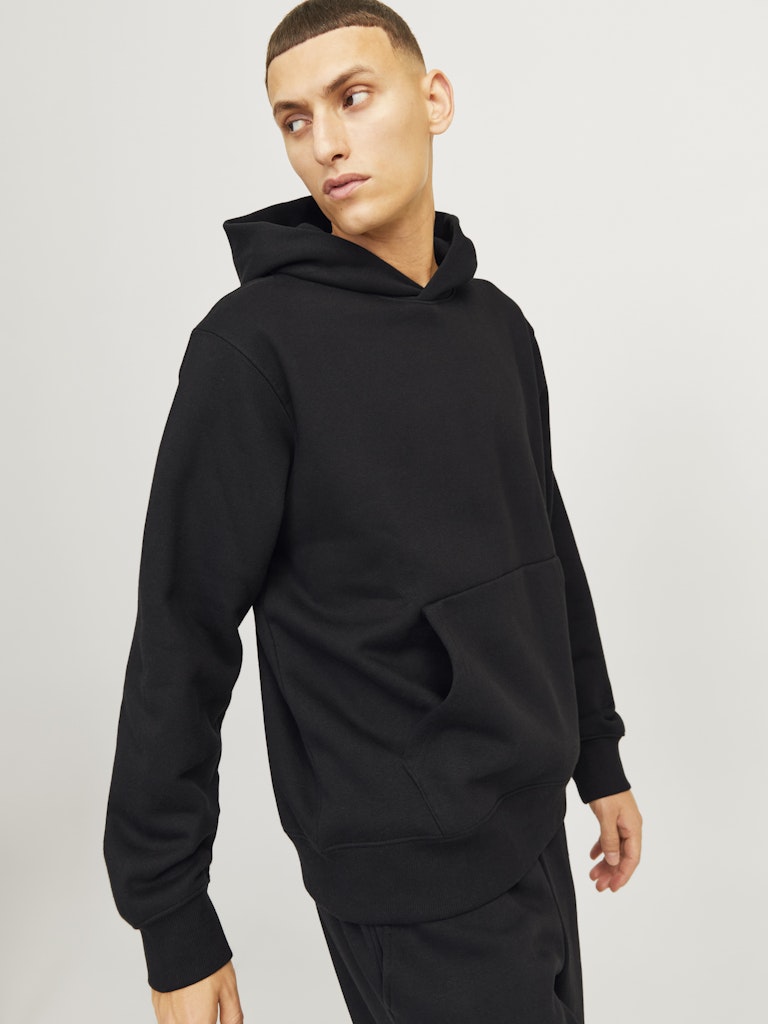 Person wearing a black hoodie on a plain background