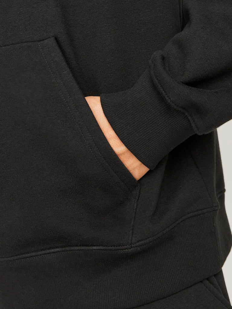 Black hoodie with a pocket on a neutral background