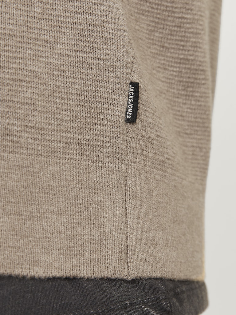 Close-up of a textured fabric with a brand label on a neutral background
