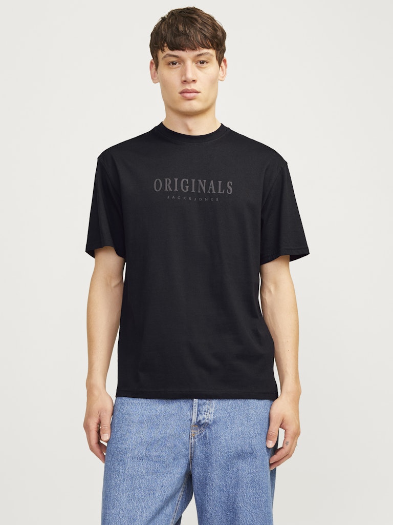 Person wearing a black t-shirt with 'ORIGINALS' text on a plain background