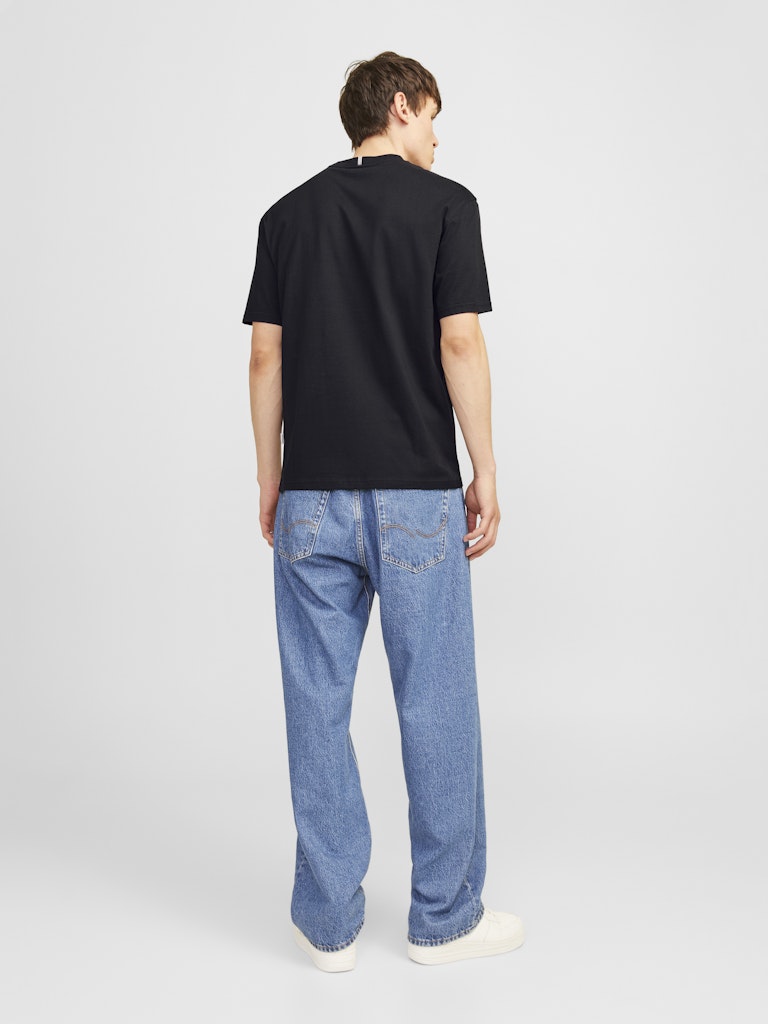 Person wearing a black t-shirt and blue jeans on a white background