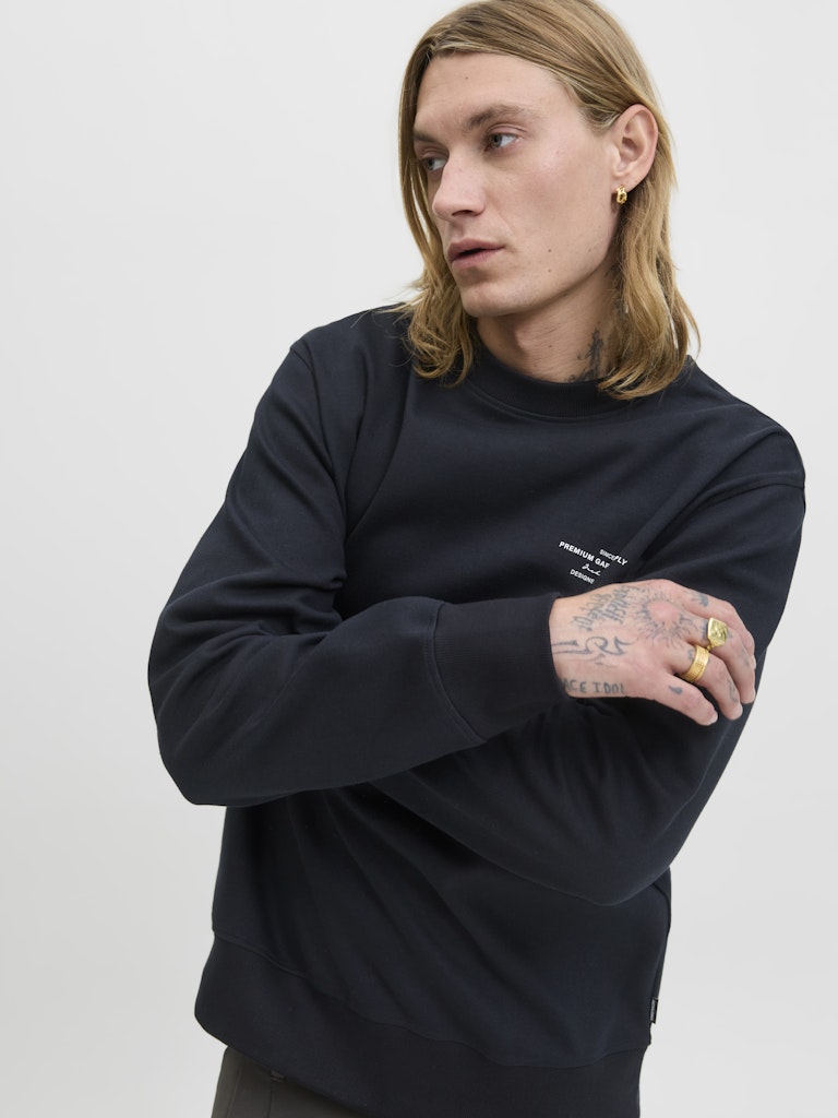 Person wearing a black sweatshirt with text on a plain background