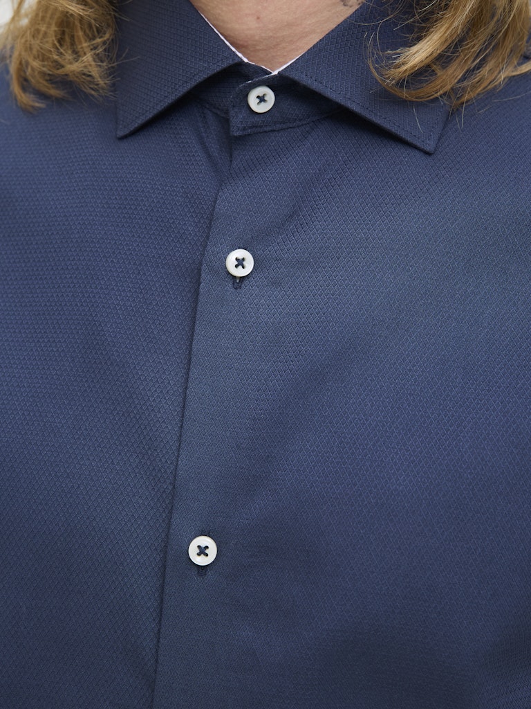 Close-up of a navy blue shirt with button details
