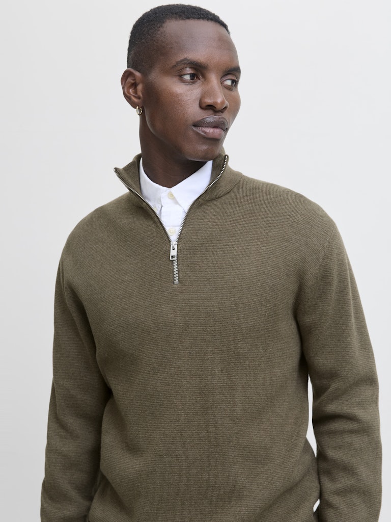 Man wearing a stone grey sweater with a white background