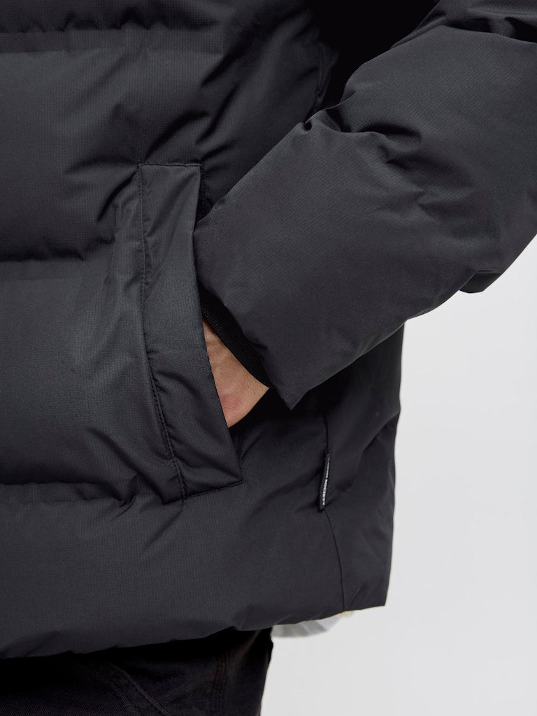 Close-up of a black puffer jacket on a light gray background