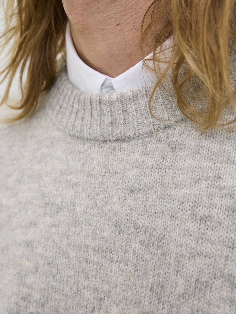 Person wearing a gray sweater on a white background-Neck detail