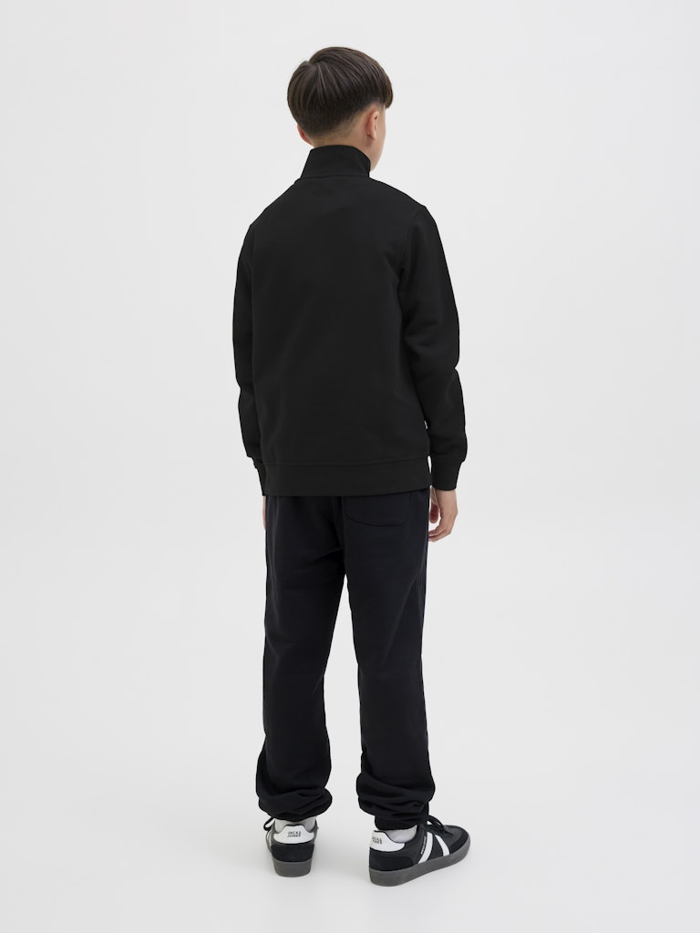 Person wearing a black tracksuit on a white background