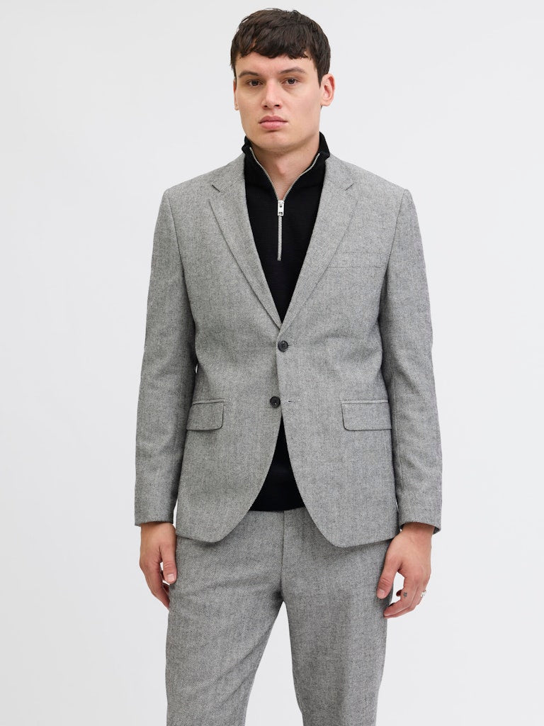 Person wearing a gray suit with a white background