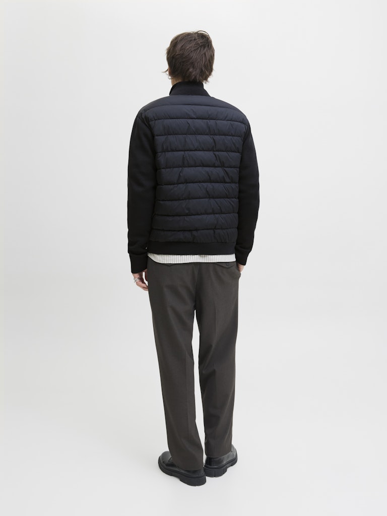 Person wearing a navy puffer jacket on a light gray background-Back view