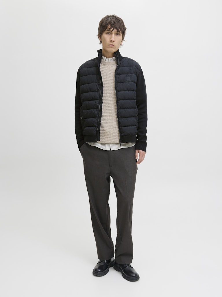 Person wearing a navy puffer jacket on a light gray background-Full model view