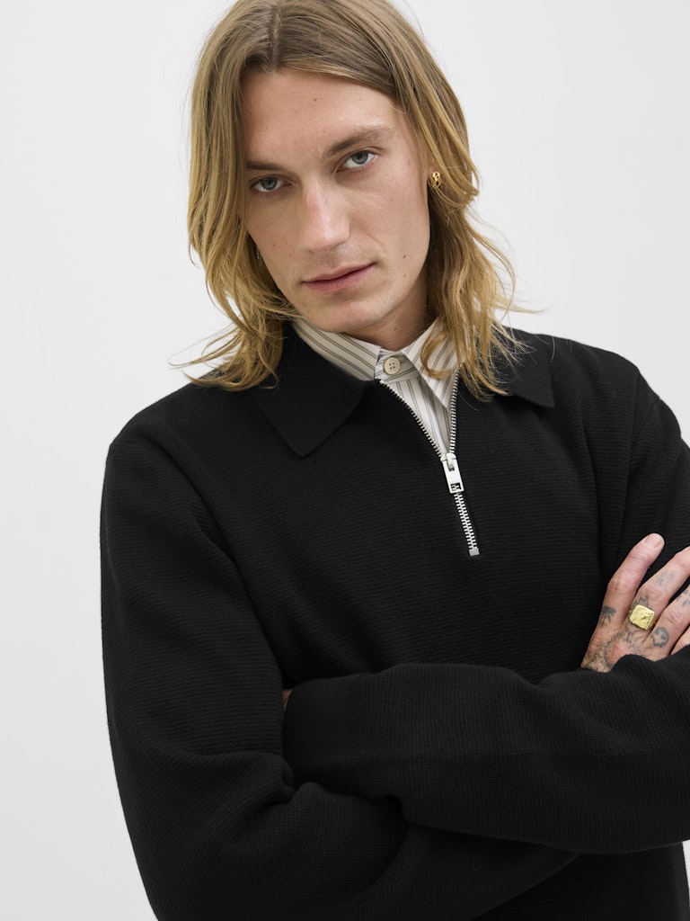 Person wearing a black polo with a white background
