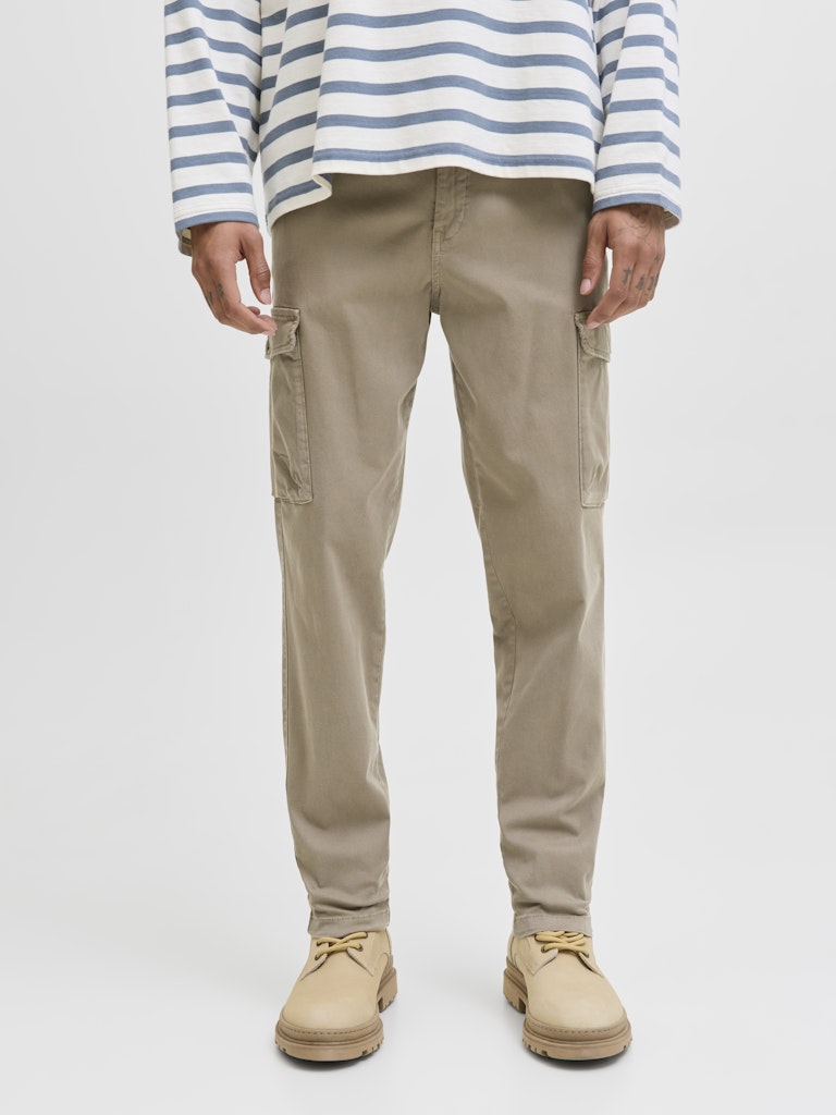 Person wearing beige cargo pants and a striped shirt on a white background