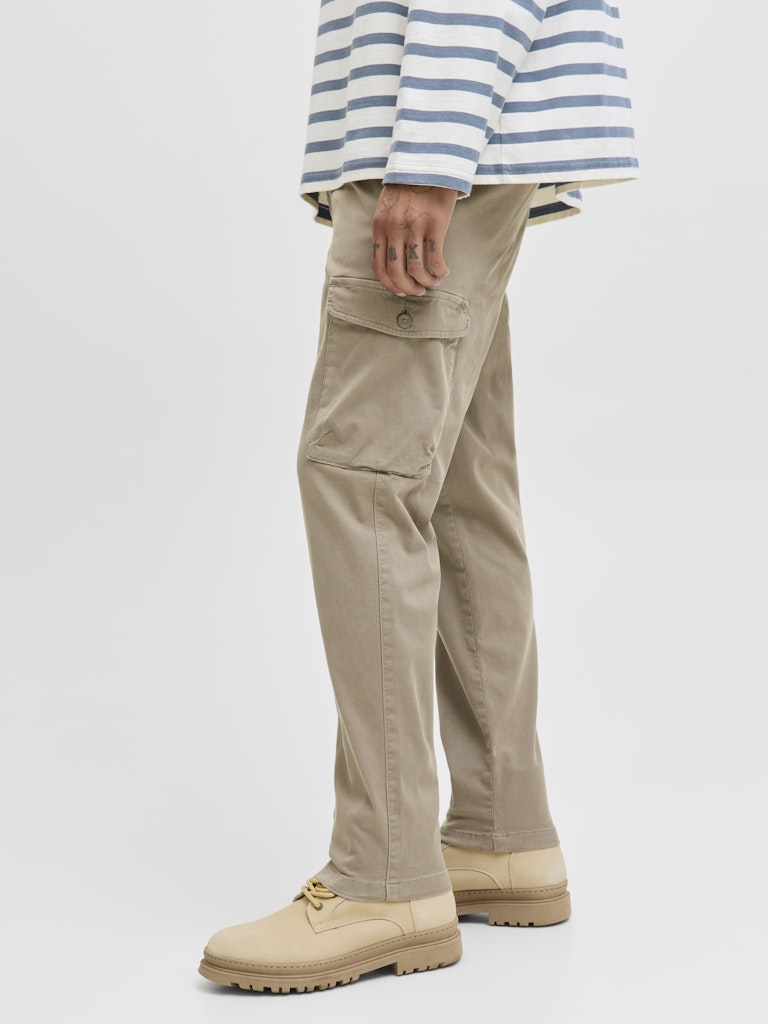 Person wearing beige cargo pants and a striped shirt on a white background