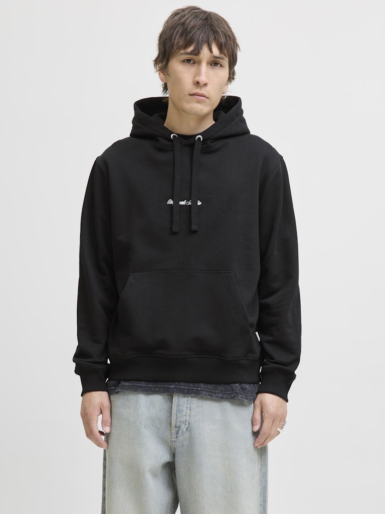 Person wearing a black hoodie on a plain background