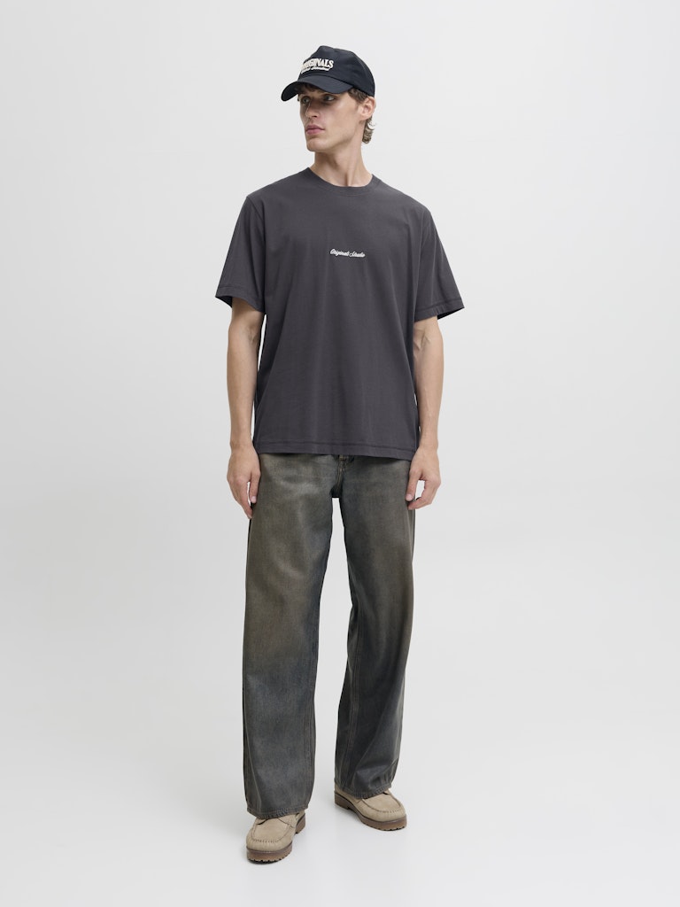 Person wearing a dark t-shirt and pants with a cap on a white background